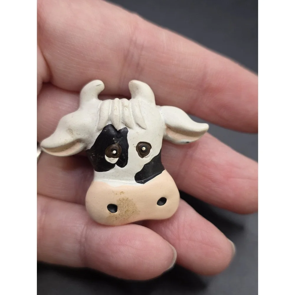 This collection features various vintage-style cow refrigerator magnets